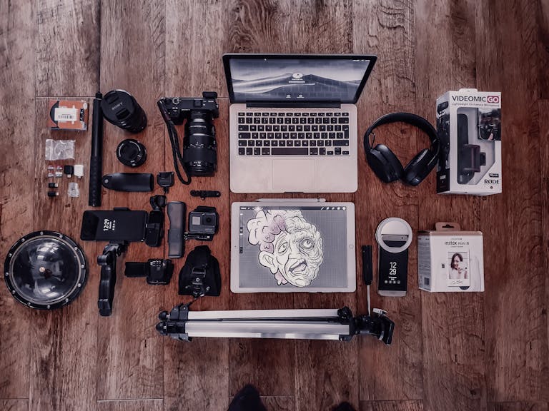 Overhead composition of laptop and graphic tablet composing with photo camera and other different items for freelance and professional photography