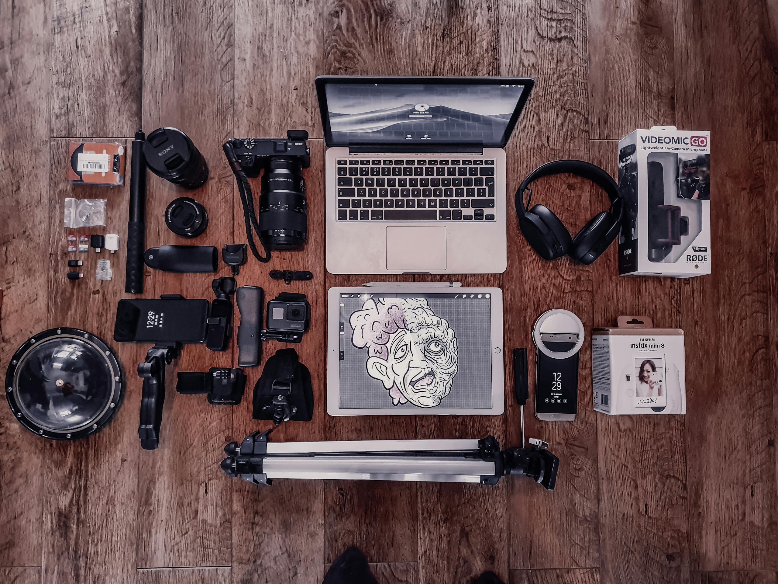 Overhead composition of laptop and graphic tablet composing with photo camera and other different items for freelance and professional photography