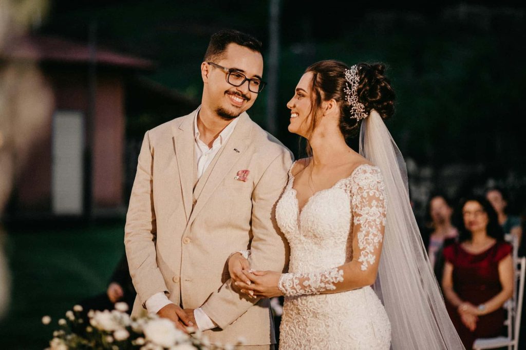 Elegancka fotografia ślubna w Katowicach – Pan Młody w beżowym garniturze i Panna Młoda w koronkowej sukni patrzący na siebie, reportaż ślubny Śląsk.