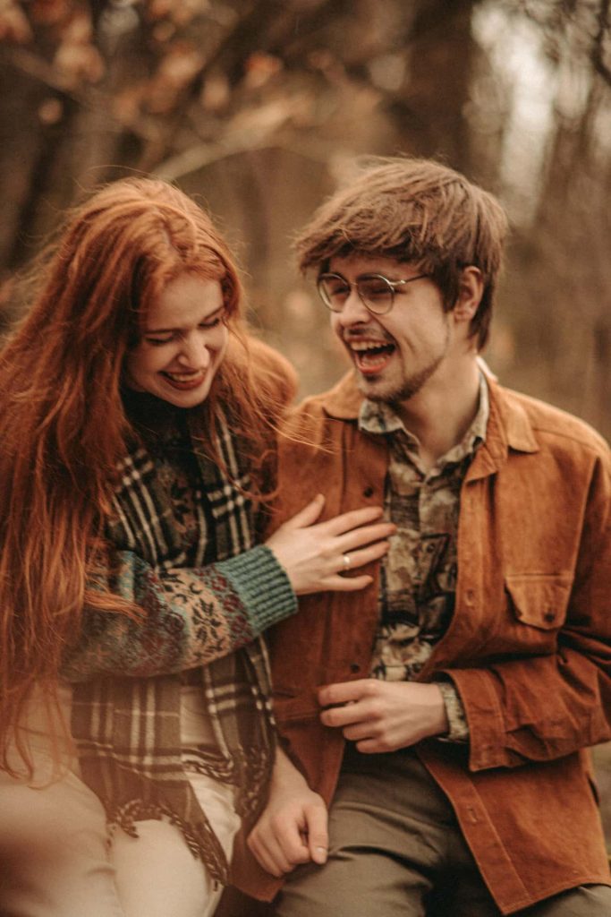 Spontaniczna sesja narzeczeńska Katowice – roześmiana para w stylu vintage, rudowłosa dziewczyna w kraciastym szalu i chłopak w okularach, jesienne kolory, fotografia lifestyle Śląsk.